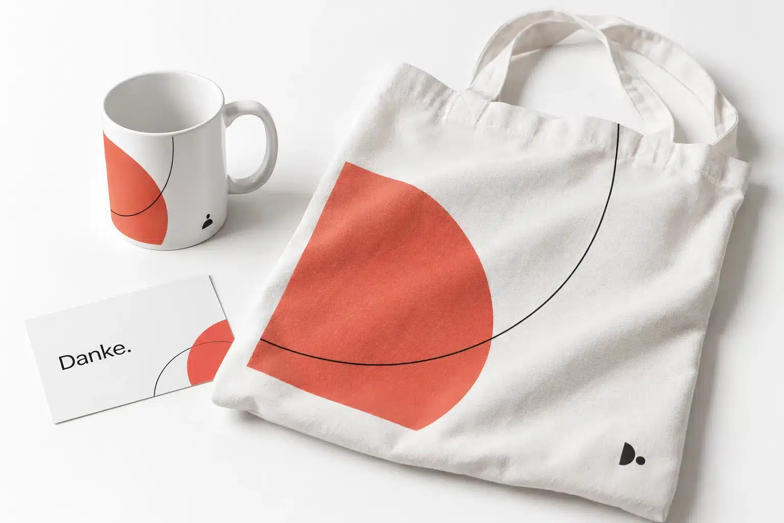 Weihnachtsmailings: Geschenke, die zu Kunden passen 7 KI-Konzept einer weißen Tasse und Stofftasche mit korallfarbenem grafischem Motiv und kleinem Markenzeichen
